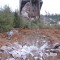 In this photograph, a large rock from the site was used to reduce the height of a bedrock outcrop in the road bed. This minimized the amount of borrow material required to cover the obstacle.